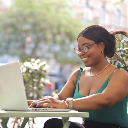 portrait-young-woman-sitting-outdoor-cafe-with-computer (1)